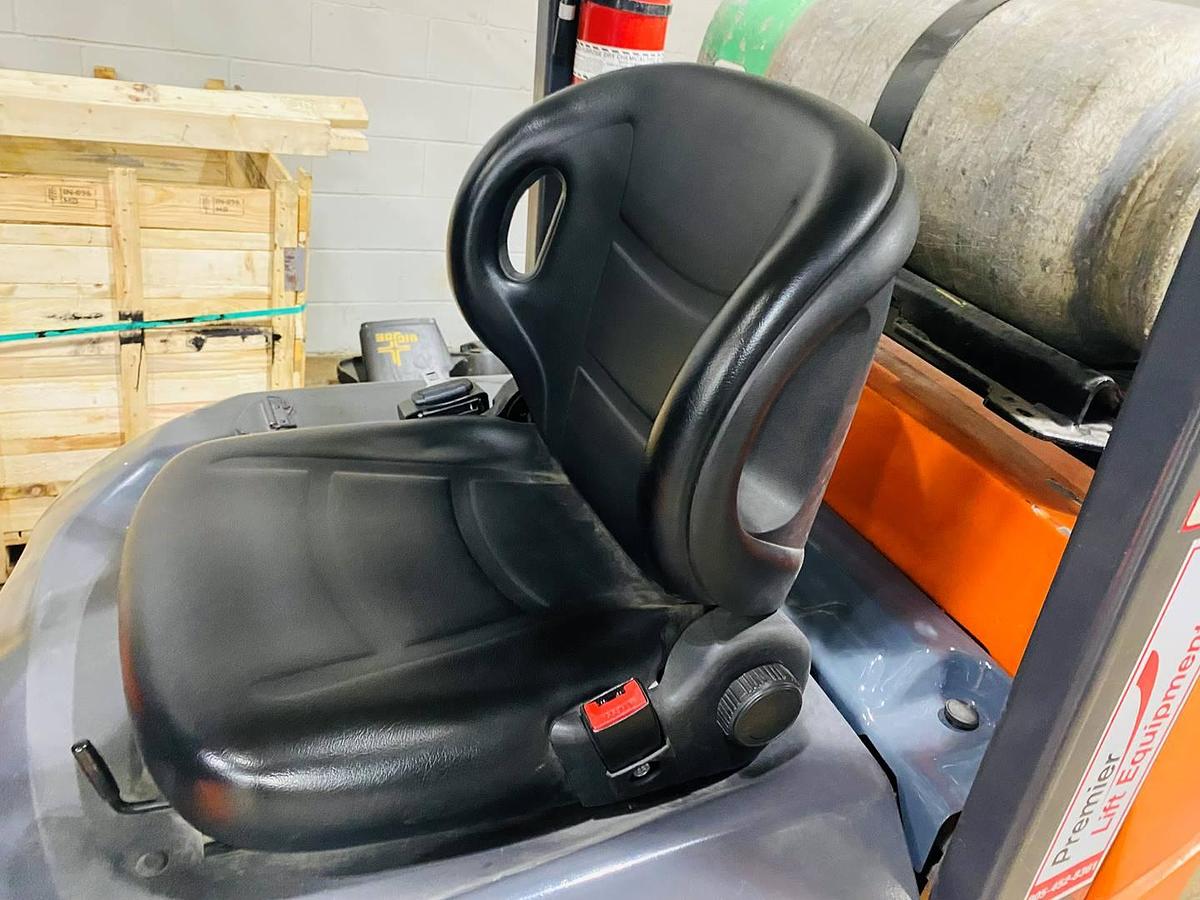 Replacement operator seat on refurbished Toyota LP gas forklift showing safety belt and comfort padding during Brampton deployment