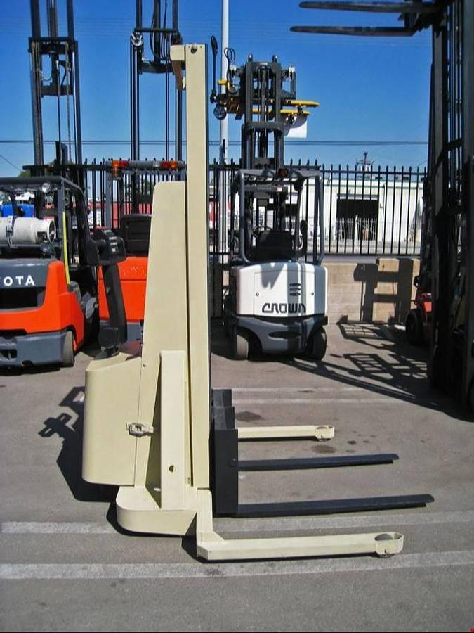 Side view of Crown W2T-130 electric walkie straddle stacker – CSA/MOL certified 2,000 lb chassis with 130” lift height, adjustable straddle legs, and built-in 110V wall charger – shown reconditioned with battery installed – Premier Lift Equipment, Brampton ON