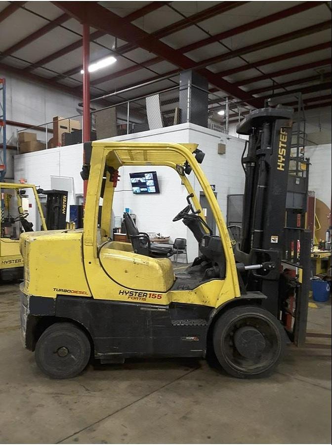 Side profile of 2012 Hyster S155FT diesel cushion forklift showing mast rails, chassis layout, and indoor tires during Brampton deployment