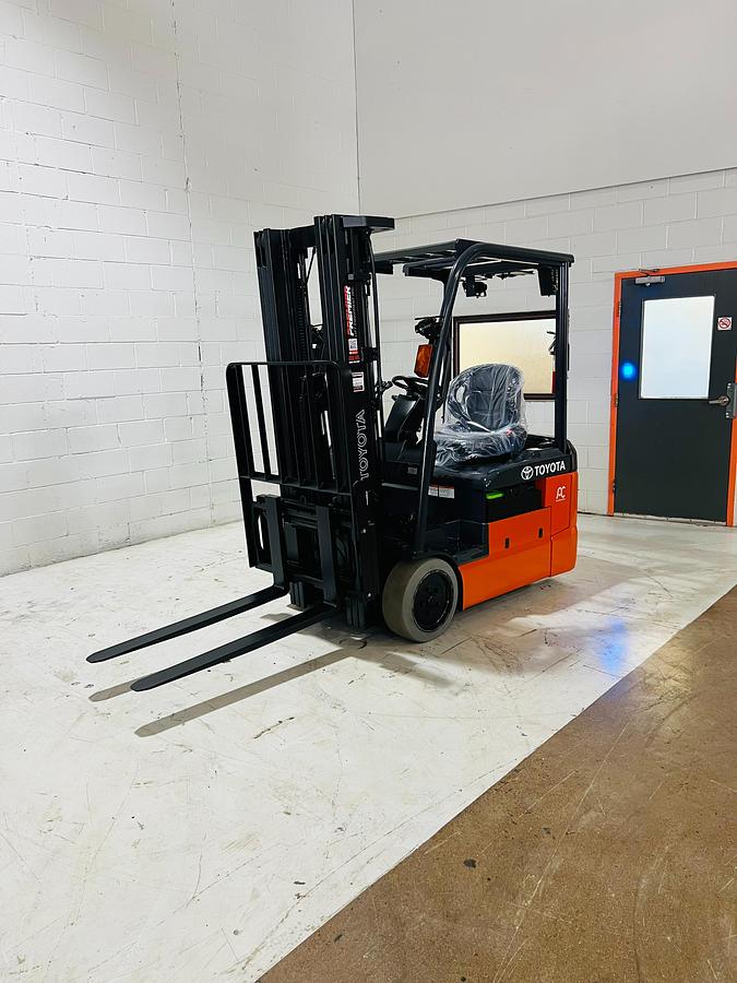 Front side‑angle view of 2021 Toyota 8FBE18U 3‑wheel electric forklift showing 189" triple mast, forks, overhead guard, and compact counterbalance chassis