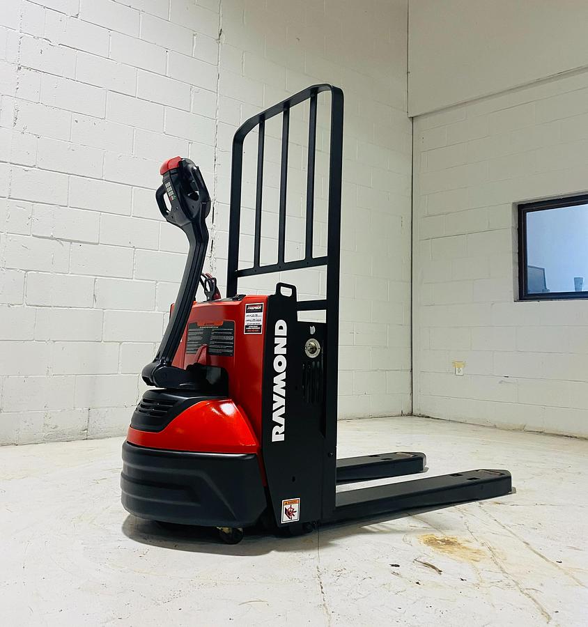 Angle view of 2020 Raymond 8210 walkie pallet jack showing compact chassis and short 27x34 forks.