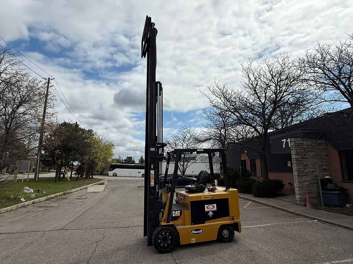 Cat E1000 – side profile with forks raised – triple mast extension, clamp-ready hydraulics, cushion tires – CSA-certified electric forklift – Brampton ON