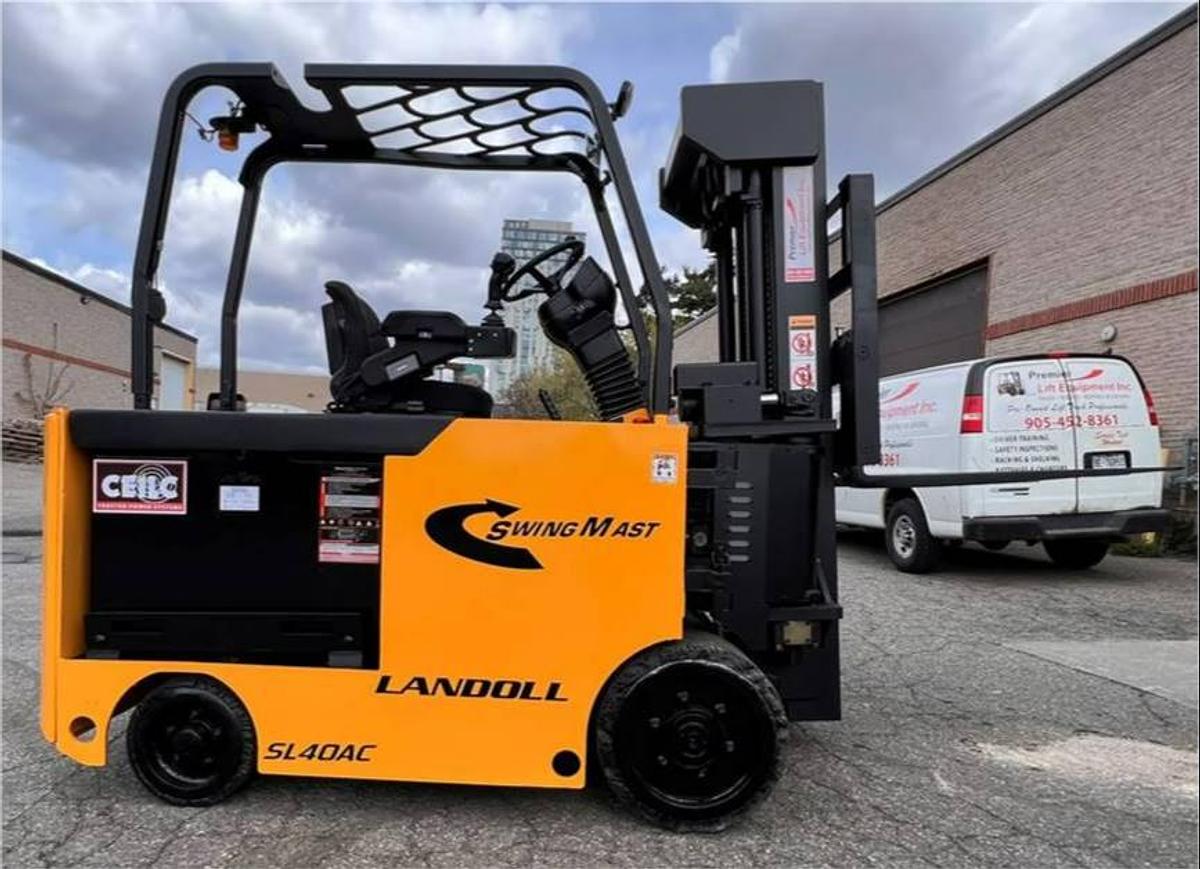 Side profile of Drexel SL-40AC SwingMast forklift showing 250" quad mast, directional wheels, and narrow chassis during Brampton deployment