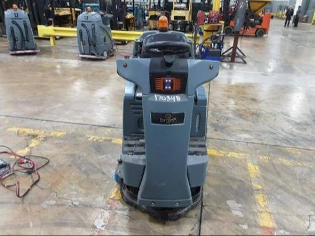 Rear view of refurbished 2019 Factory Cat RS25 electric rider sweeper‑scrubber showing rear chassis, 26" wide cleaning path housing, 24 volt battery compartment, compatible charger mount, and CSA/MOL certification decal during Brampton deployment.