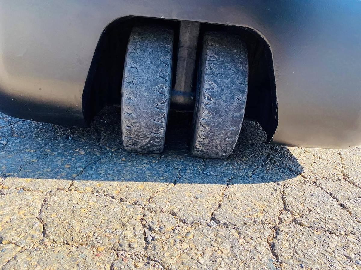 Back wheels of refurbished 2018 EP Equipment CPD20 3‑wheel electric forklift showing dual rear solid pneumatic tires, counterweight, and CSA certification decal during Brampton deployment.