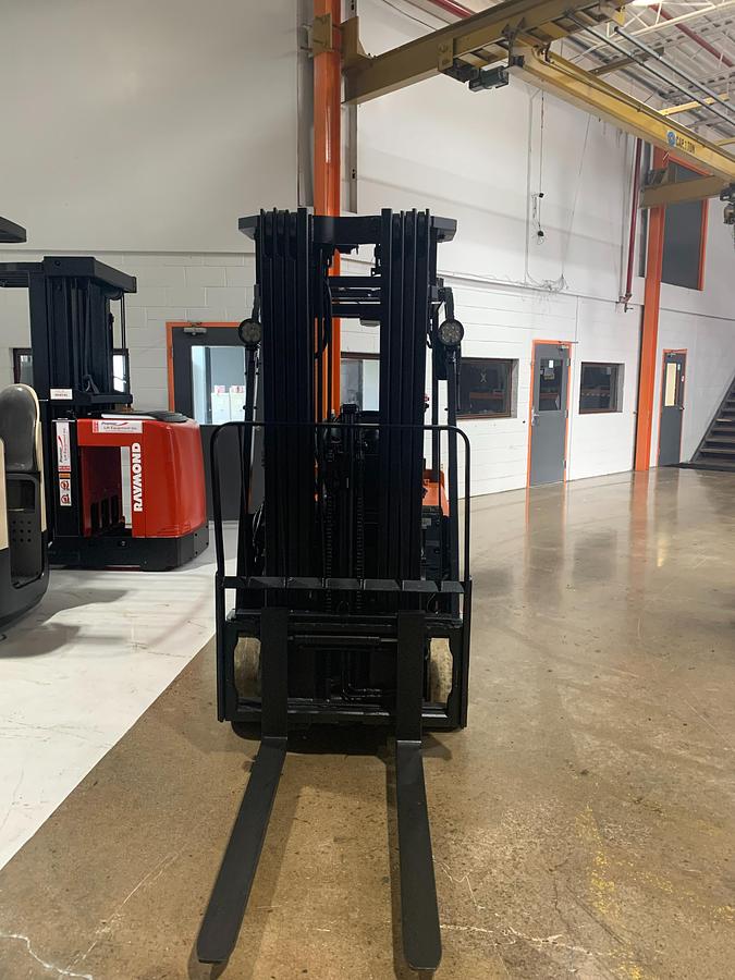 Head-on view of 2014 Toyota 7FBEU20 electric forklift with forks lowered, quad mast extended, and CSA safety markings visible