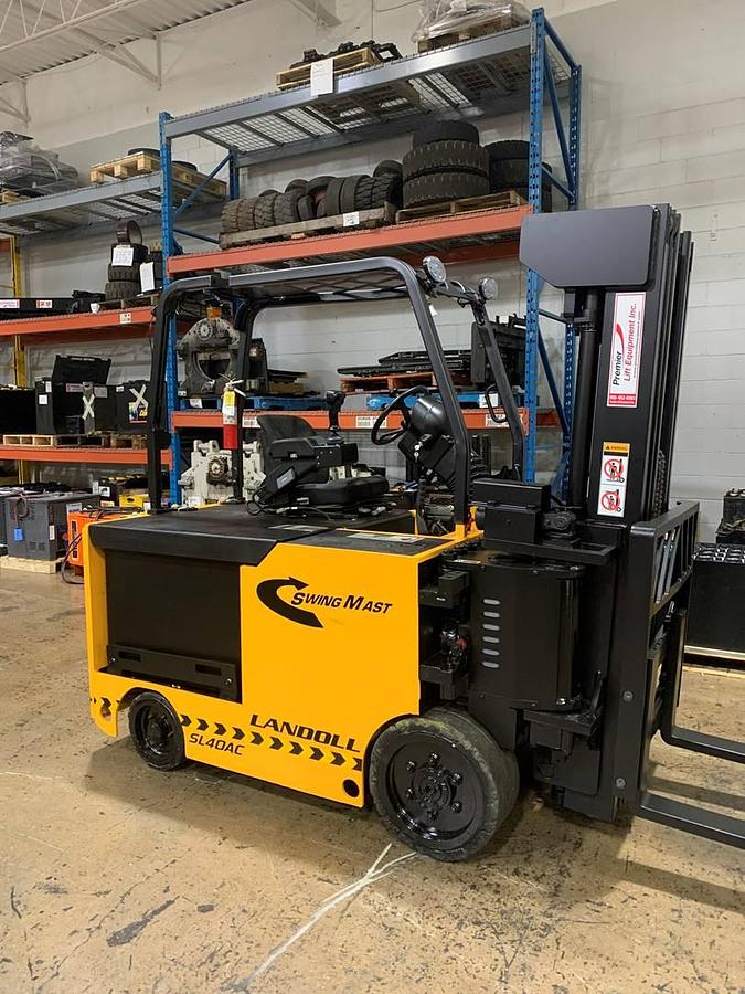 Side profile of 2017 Drexel SL-40AC electric SwingMast forklift showing pivoting mast, directional wheels, and narrow chassis during Brampton deployment