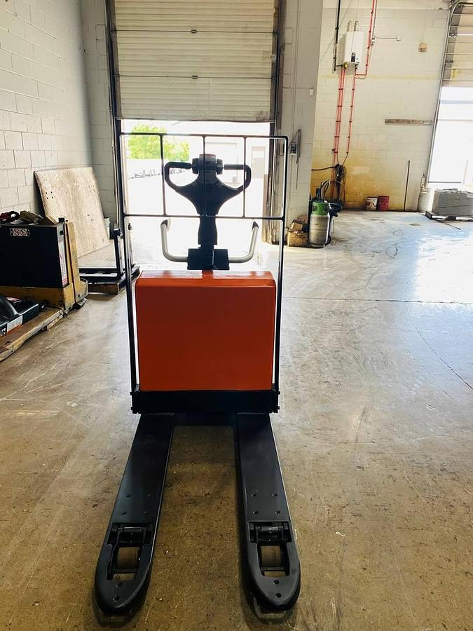 Front view of refurbished 2016 BT LPE200/8 electric walkie/rider pallet jack showing 27" x 45" forks, flip‑down operator platform, load backrest, and CSA certification decal during Ontario deployment.