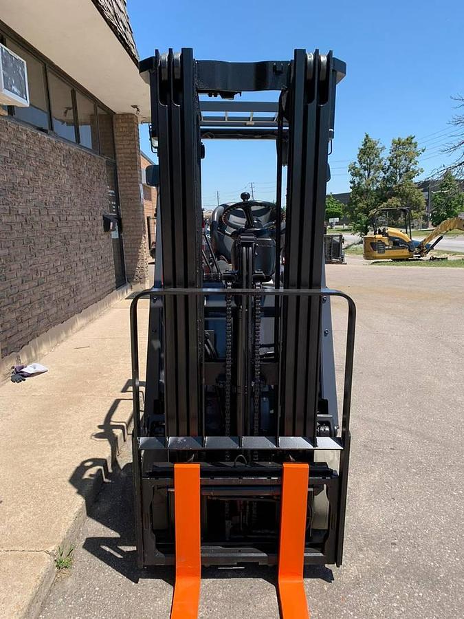 Front view of refurbished 2008 Toyota 7FBCU18 electric 4-wheel sit-down forklift showing fork carriage, mast rails, and side shift mechanism during Ontario deployment