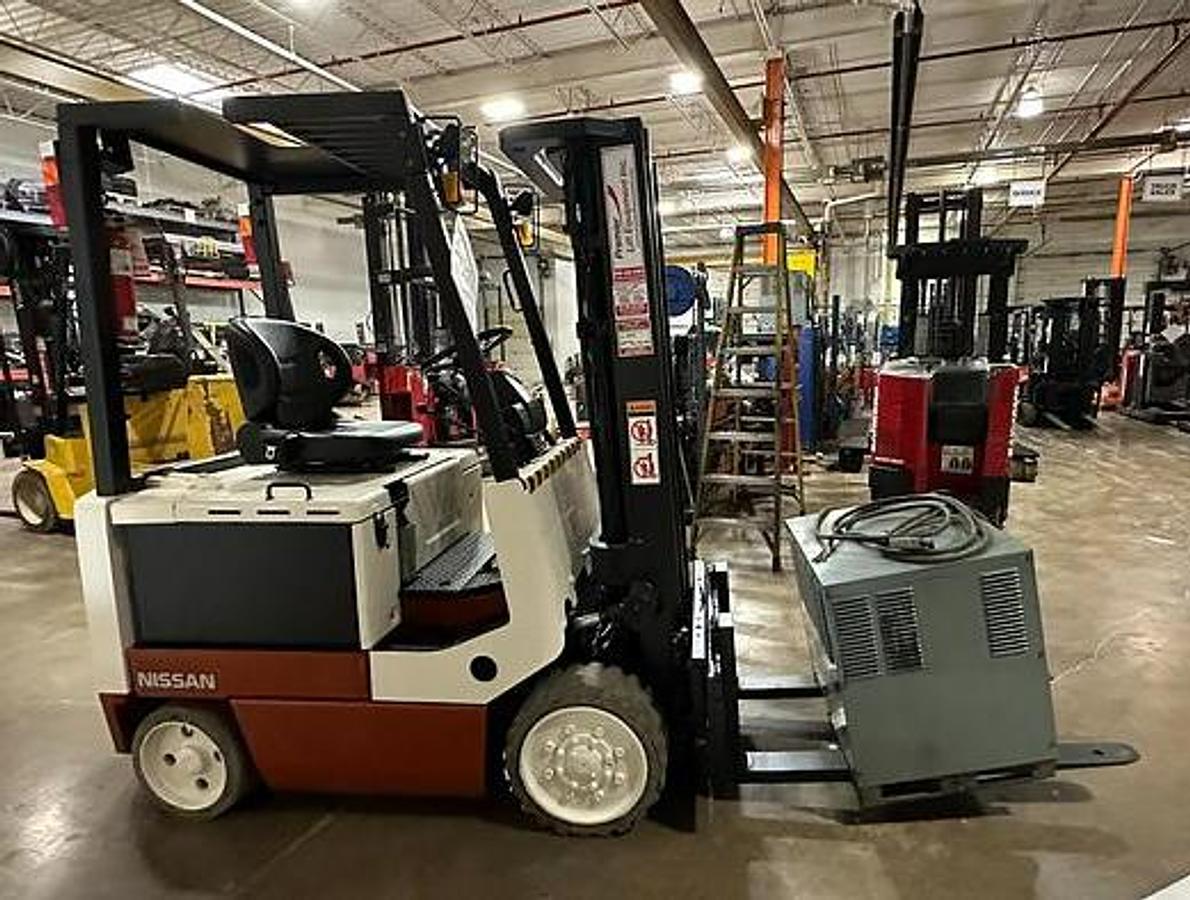 Opposite side view of Budget Nissan CWP02L25S older electric forklift, non‑CSA.