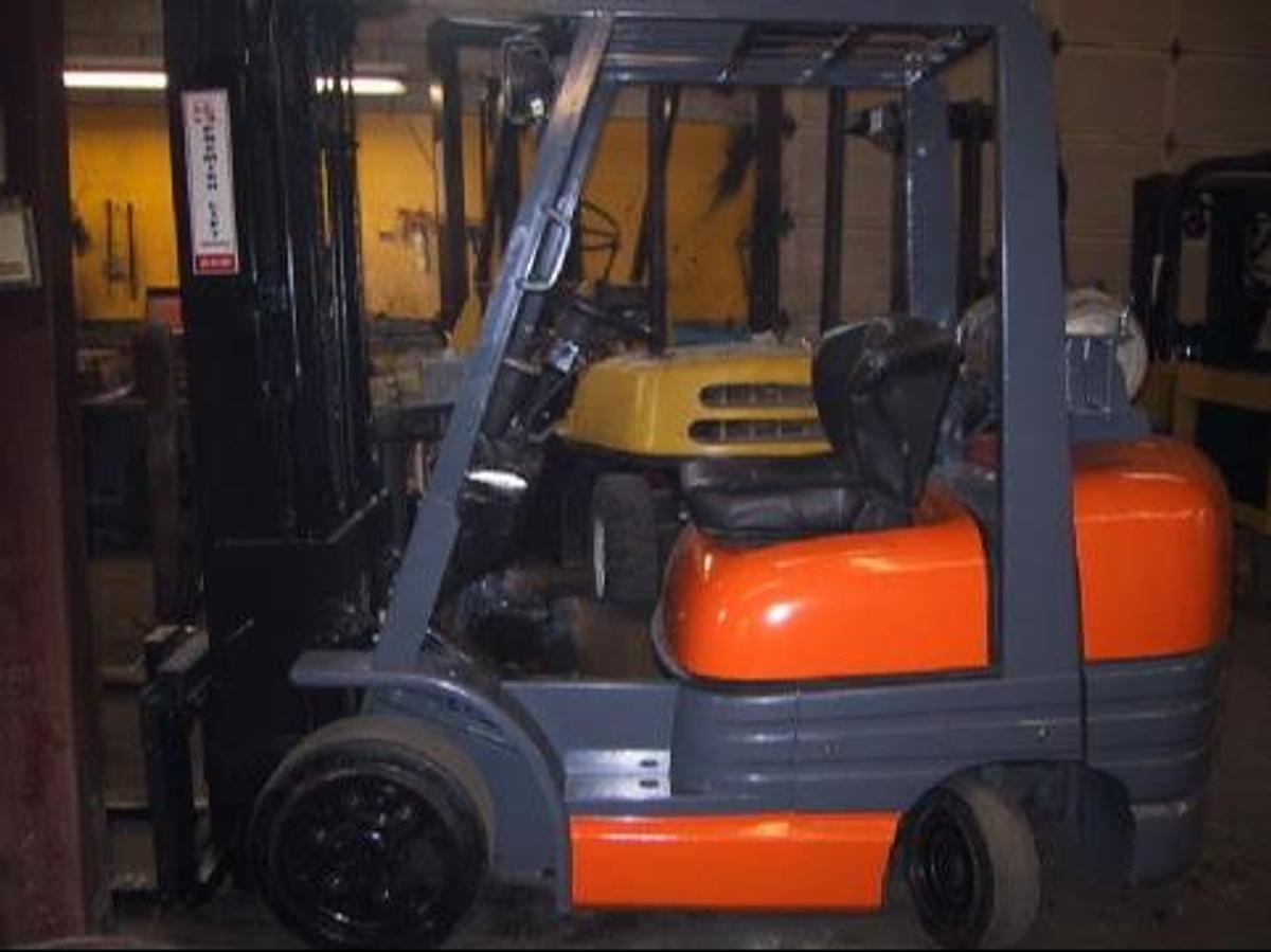 Side view of vintage refurbished 1999 Toyota 42-6FGCU25 LP gas forklift showing operator cab, rear chassis, and CSA decal during Brampton deployment