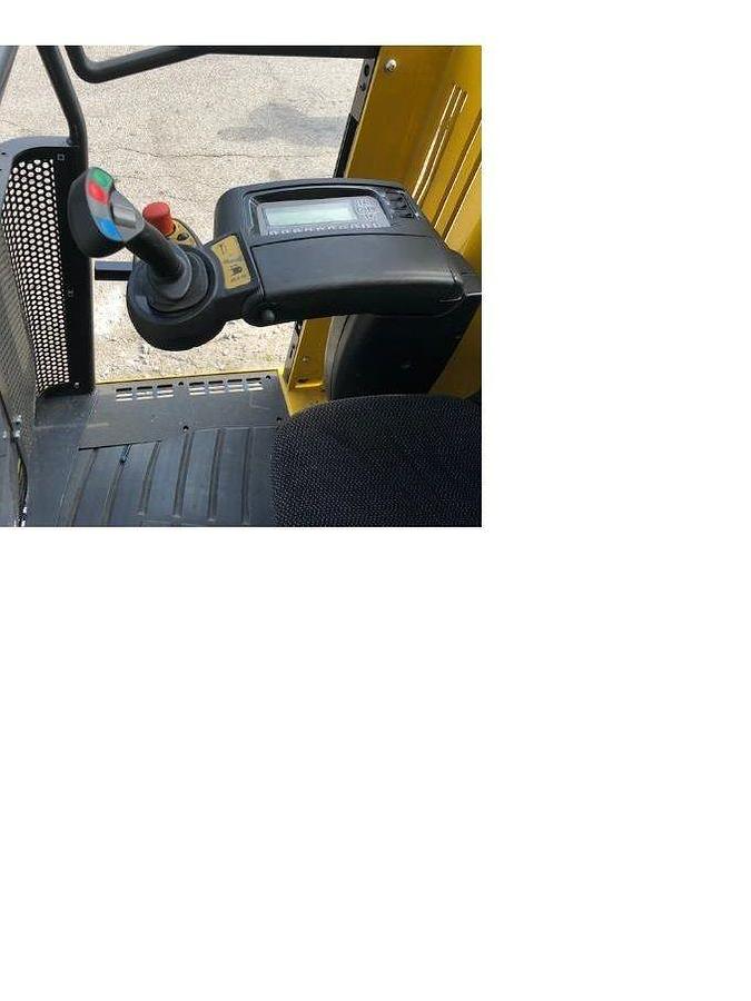 Close‑up view of refurbished 2013 Yale NTA030SB electric man‑up swing reach turret truck showing operator joystick controls beside seat, hour meter, and CSA certification decal during Ontario deployment.