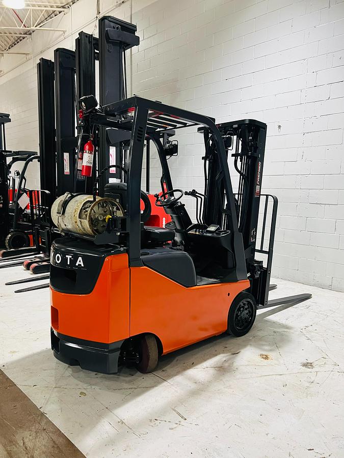 Opposite side angle of 2020 Toyota 8FGCU18 propane forklift – CSA-certified 3,500 lb cushion tire chassis with 189” triple mast, fork positioner, and propane tank bracket shown reconditioned with safety decals applied, Brampton ON – Premier Lift Equipment