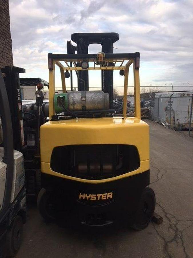 Rear view of refurbished 2014 Hyster S155FT LPG cushion forklift showing counterweight, rear tires, and propane tank bracket during Brampton deployment