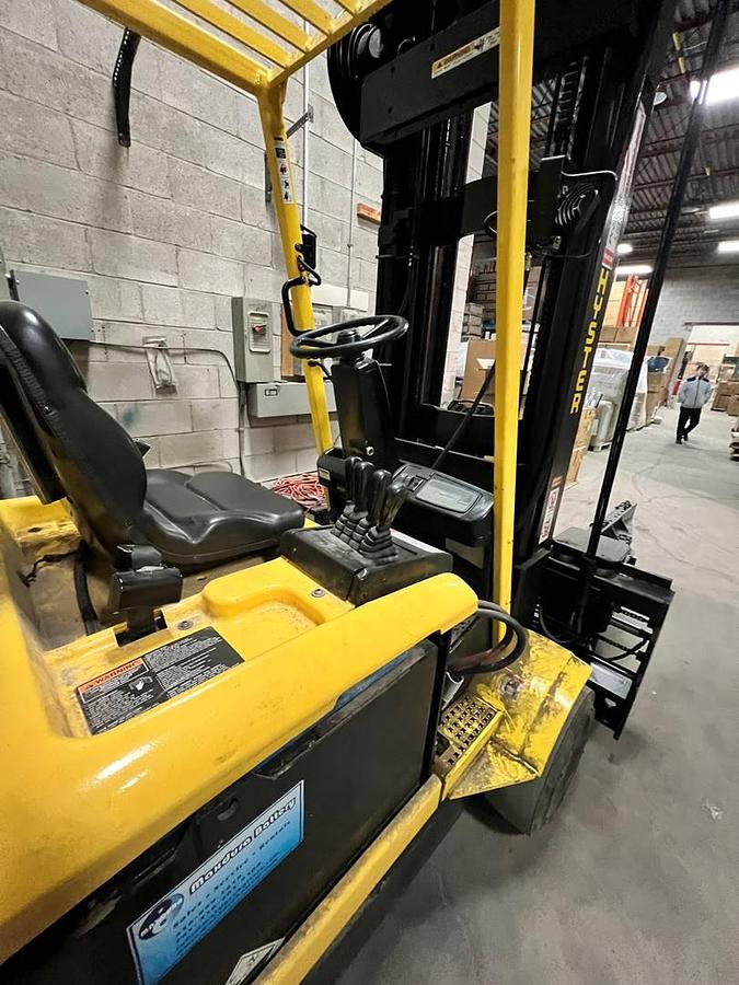 Operator compartment of refurbished Hyster N30XMH electric man‑down turret truck showing man‑down operator area, steering controls, turret mast controls, battery indicator, and CSA certification decal during Ontario deployment.