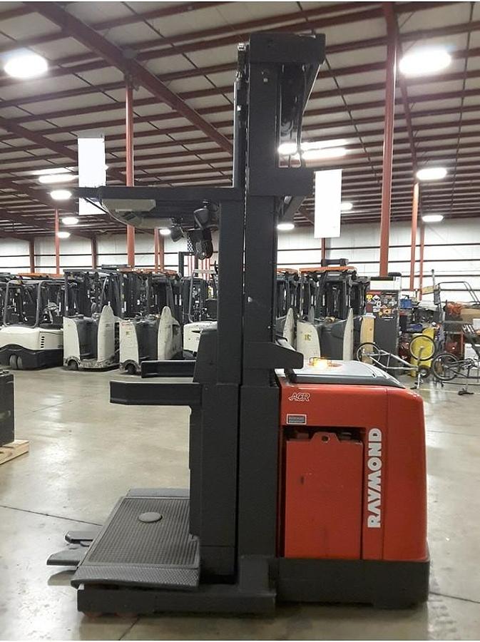 Side view of refurbished 2011 Raymond 560-OPC30TT electric order picker showing battery compartment, chassis frame, and platform base during Toronto deployment