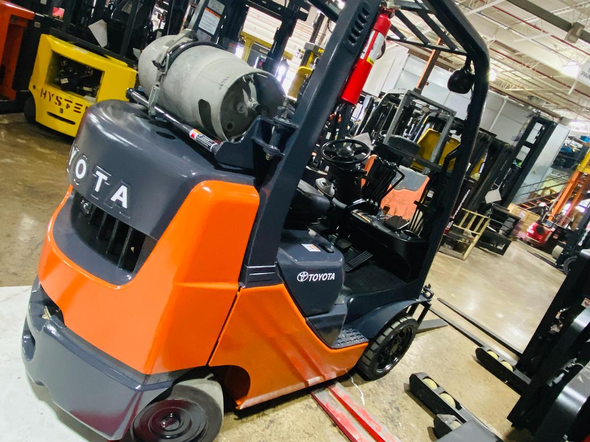 Back side angle of 2011 Toyota 8FGCU20 propane forklift – CSA-certified 4,000 lb chassis showing rear counterweight, propane tank mount, and traction cushion tires with safety decals applied, Brampton ON – Premier Lift Equipment