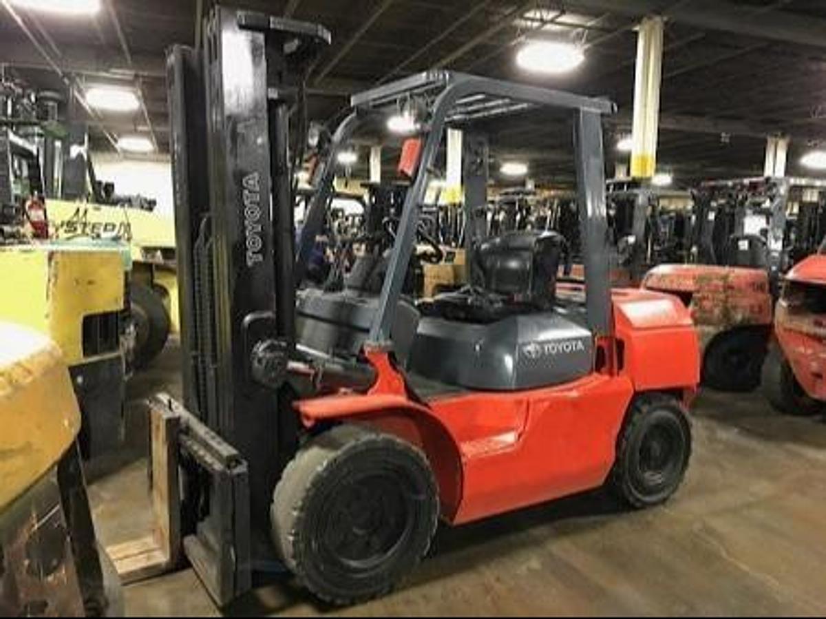 Opposite front side view of refurbished 2008 Toyota 7FGU35 LP gas forklift showing mast, forks, operator cab, and solid tire chassis during Brampton deployment