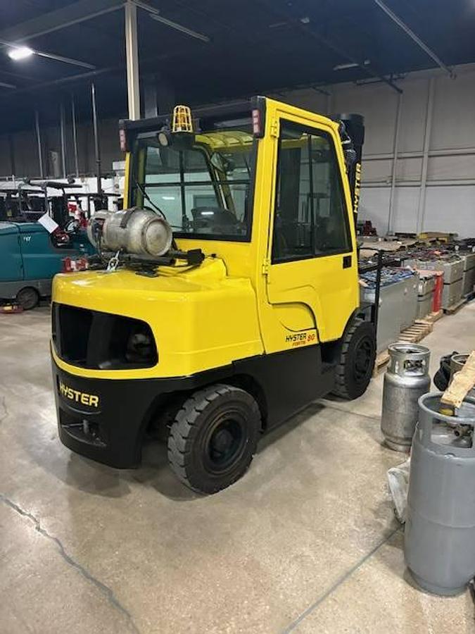 Opposite rear side view of refurbished 2011 Hyster H80FT LP Gas forklift showing counterweight, solid pneumatic tires, rear chassis, and CSA certification decal during Ontario deployment.
