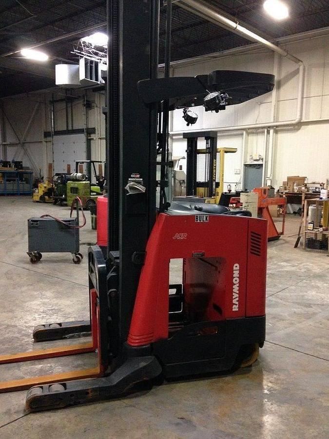 Side view of refurbished 2007 Raymond 740-R35TT electric reach truck showing chassis frame, caster wheel housing, and reach channel during Toronto deployment