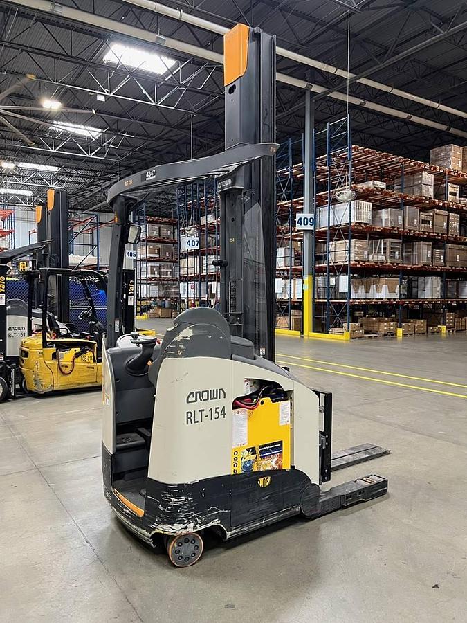 Rear opposite side view of refurbished 2021 Crown RM6095S electric reach truck showing operator compartment, rear chassis, 36 volt battery compartment, and CSA certification decal during Ontario deployment.