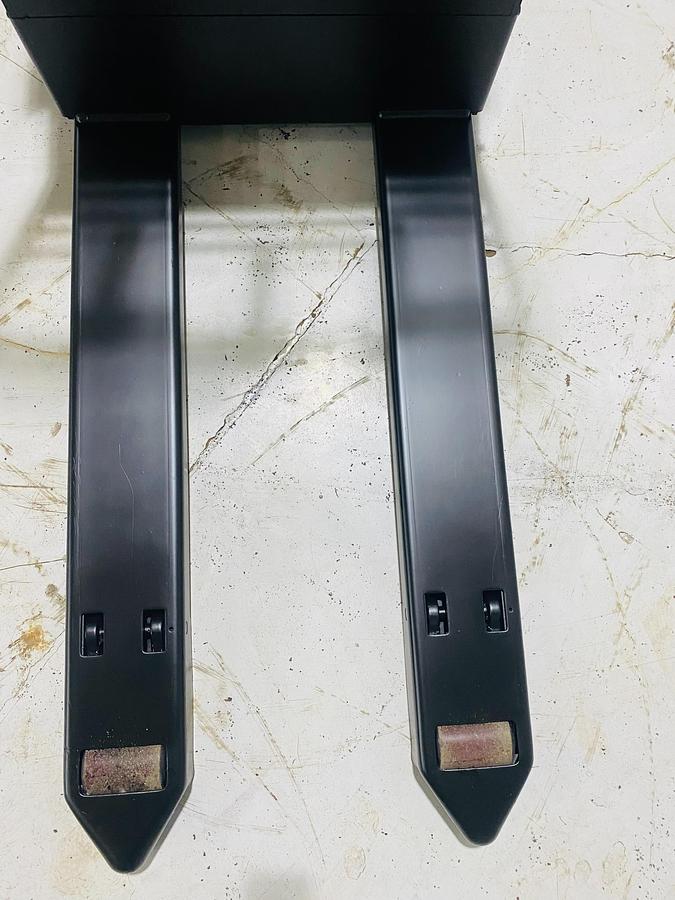 Top-down view of 27” x 45” tapered forks on 2018 Raymond 8210 electric walkie pallet jack shown chassis only without battery or charger – CSA-certified 4,500 lb unit featuring reinforced fork tips, Class II carriage, and ergonomic layout staged in Brampton ON; battery and charger available separately as extra options new or used – Premier Lift Equipment