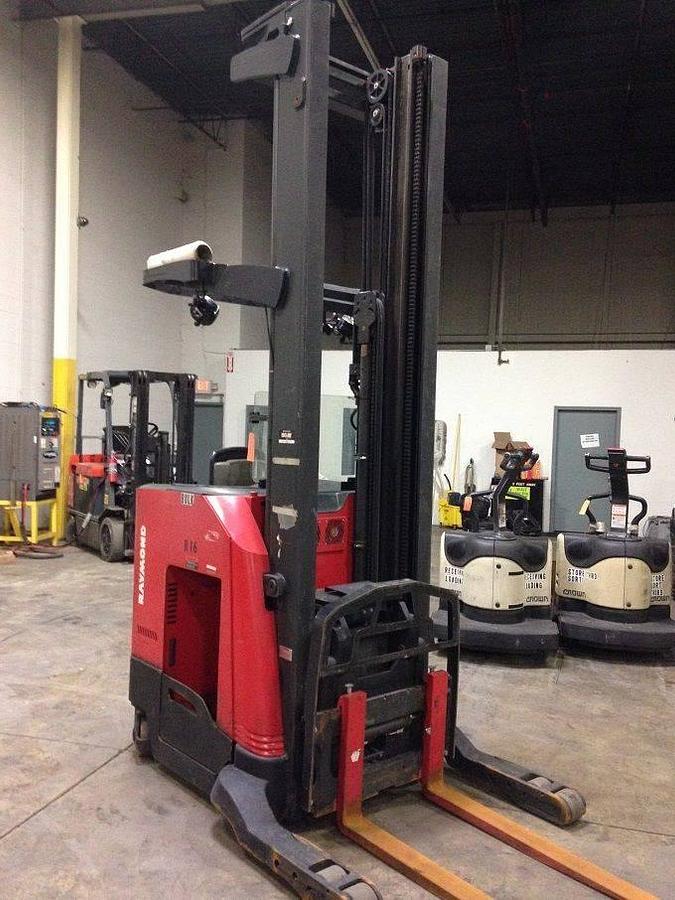 Front side angle view of refurbished 2007 Raymond 740-R35TT electric reach truck showing mast base, fork carriage, and narrow chassis rails during Toronto deployment