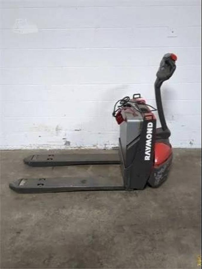 opposite side view of refurbished 2018 Raymond 8250 electric walkie pallet truck showing drive unit cover, tiller arm, and fork tips during Mississauga deployment