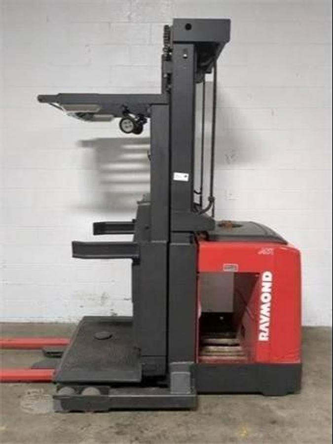 Opposite side view of refurbished 2014 Raymond 560-OPC30TT electric order picker showing chassis frame, drive unit cover, and platform base during Vaughan deployment