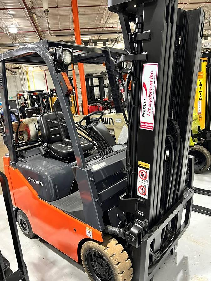 Front side view of refurbished 2007 Toyota 8FGCU15 LP gas forklift showing triple mast, 42" forks, and solid non-marking tires during Brampton deployment
