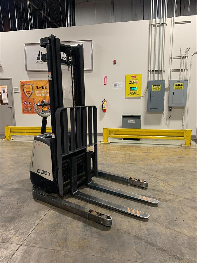 Opposite angle view of Crown SX3000-40 electric walkie straddle stacker showing fork tips, straddle base legs, and CSA-certified chassis – unit staged in Brampton ON