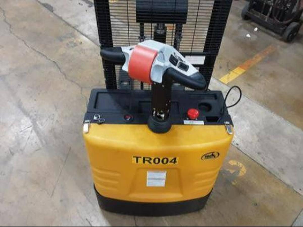 Operator compartment of refurbished 2019 Vestil S‑62‑FF forkoover stacker showing steering handle, electric controls, 27"x 42" forks, 2‑stage mast, and CSA certification decal during Brampton deployment.