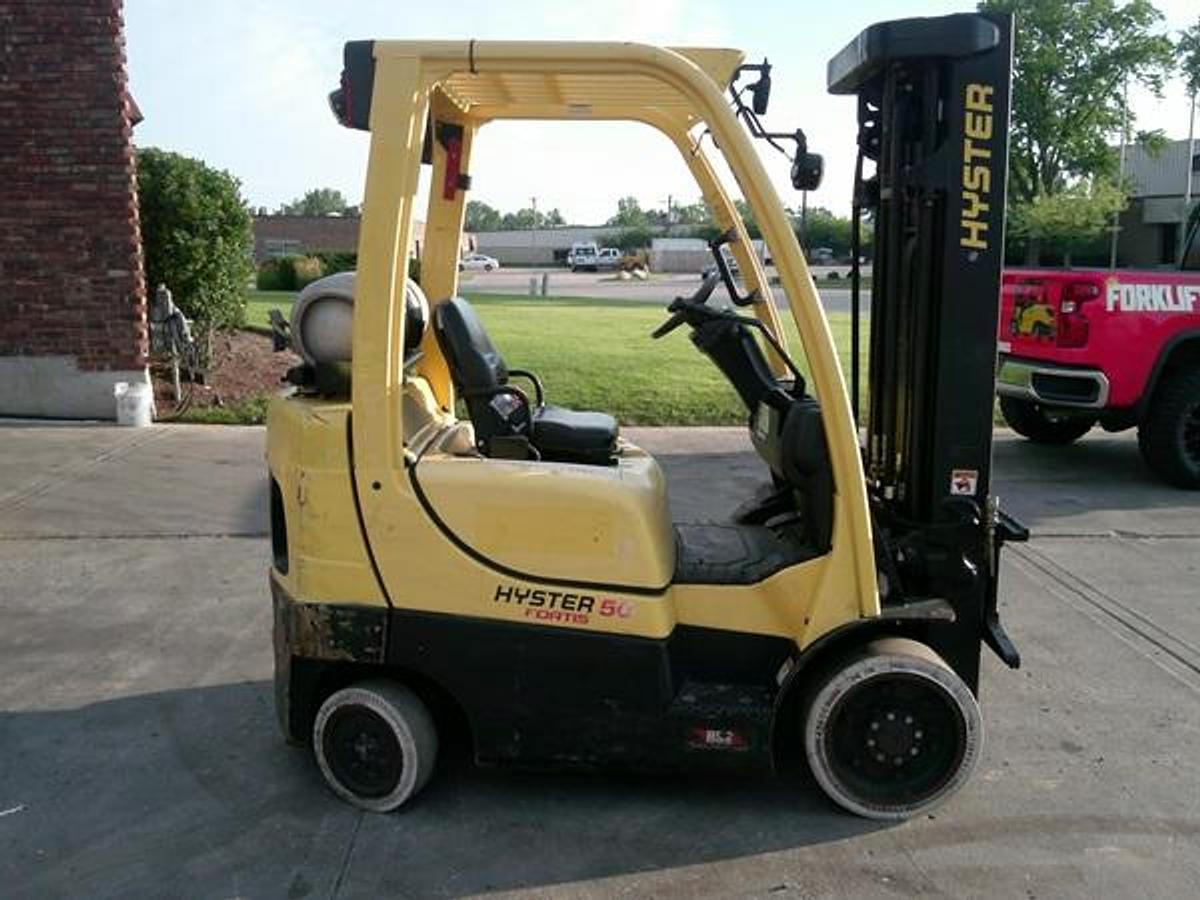 Side view of a 2019 Hyster S50FT 5,000 lb LPG cushion‑tire forklift with 83/189 triple mast and 4‑way hydraulics, running and operating for indoor warehouse use