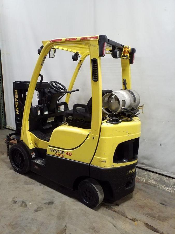 Opposite rear side view of refurbished 2014 Hyster S40FT LP Gas forklift showing counterweight, cab enclosure, solid black tires, headlights, and CSA certification decal during Ontario deployment.