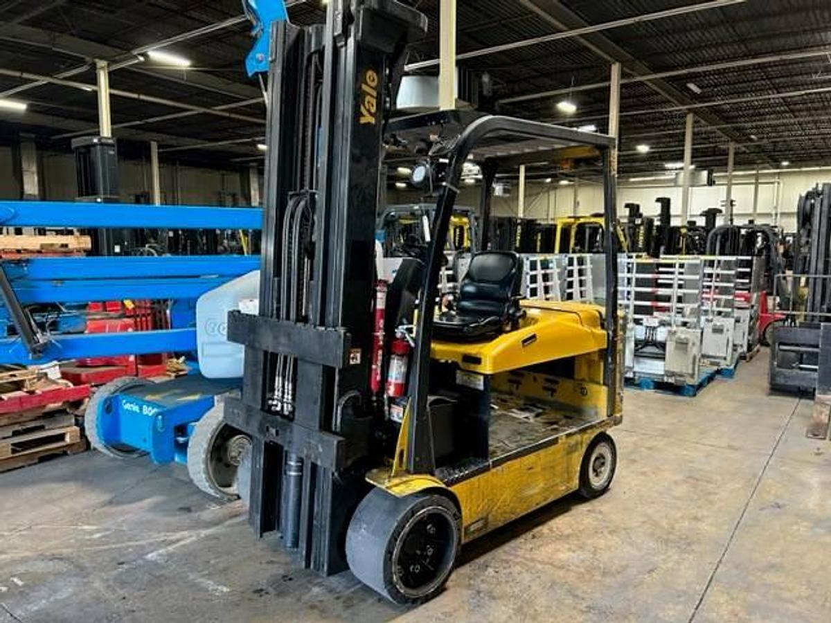 Opposite front side view of refurbished 2016 Yale ERC120VHN electric forklift showing mast, forks, operator cab, and cushion tire chassis during Brampton deployment