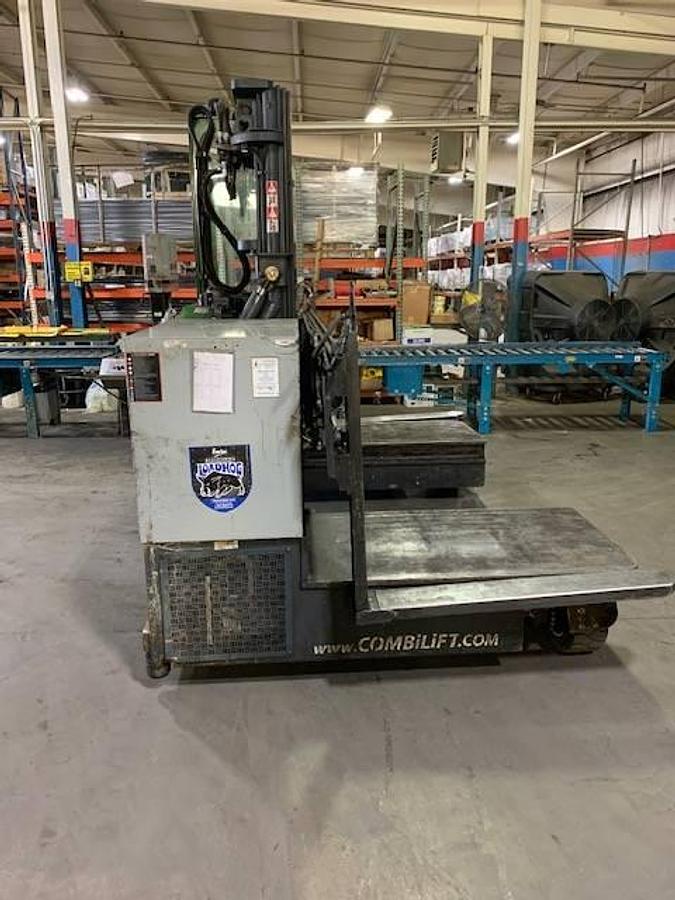 Opposite side view of refurbished 2013 Combilift C6000EST electric multi‑directional forklift showing operator compartment, 48" forks, 48" platform, 216" mast, solid pneumatic tires, and CSA certification decal during Ontario deployment.