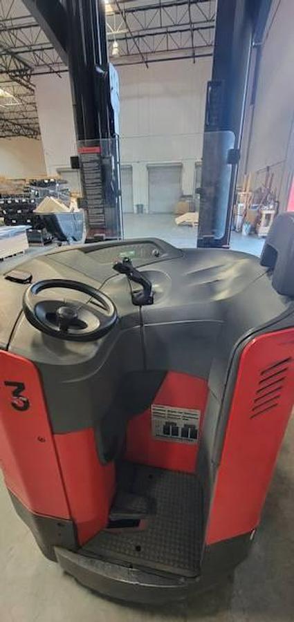 Operator dash of 2007 Raymond 740DR32TT electric deep-reach forklift showing steering wheel, instrument panel, and CSA safety decals during Brampton deployment