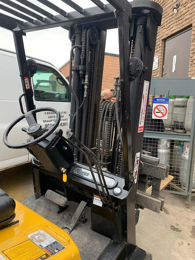 Close-up of Yale GLC050DEJUA083 operator compartment showing steering wheel, hydraulic levers, and instrument cluster during Brampton deployment