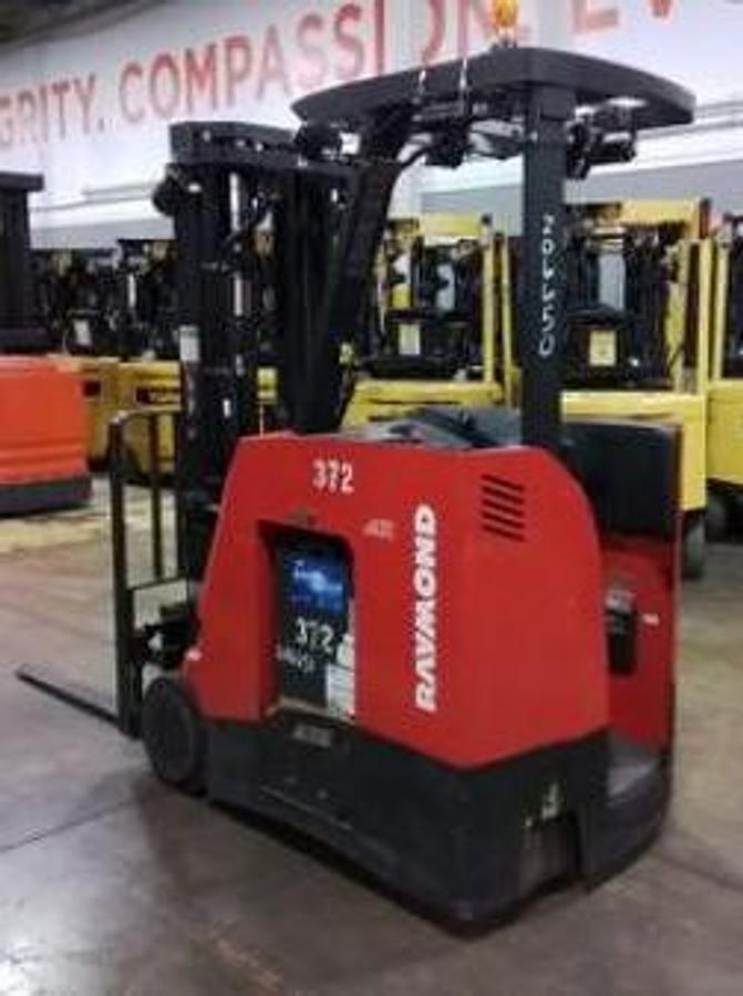 Opposite rear angle view of Raymond 425-C35TT electric stand-up counterbalance forklift with battery installed – CSA-certified 3,500 lb chassis showing rear counterweight, operator platform, and mast from alternate angle, staged in Brampton ON – Premier Lift Equipment