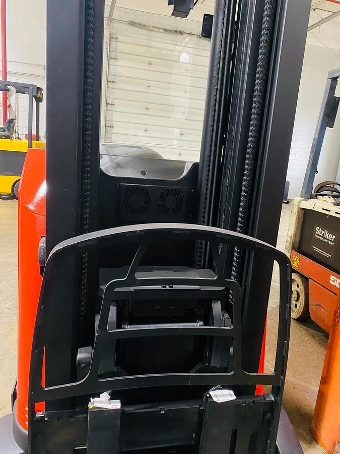 “Front view of reach‑truck carriage with load backrest — forks, carriage frame, and backrest guard