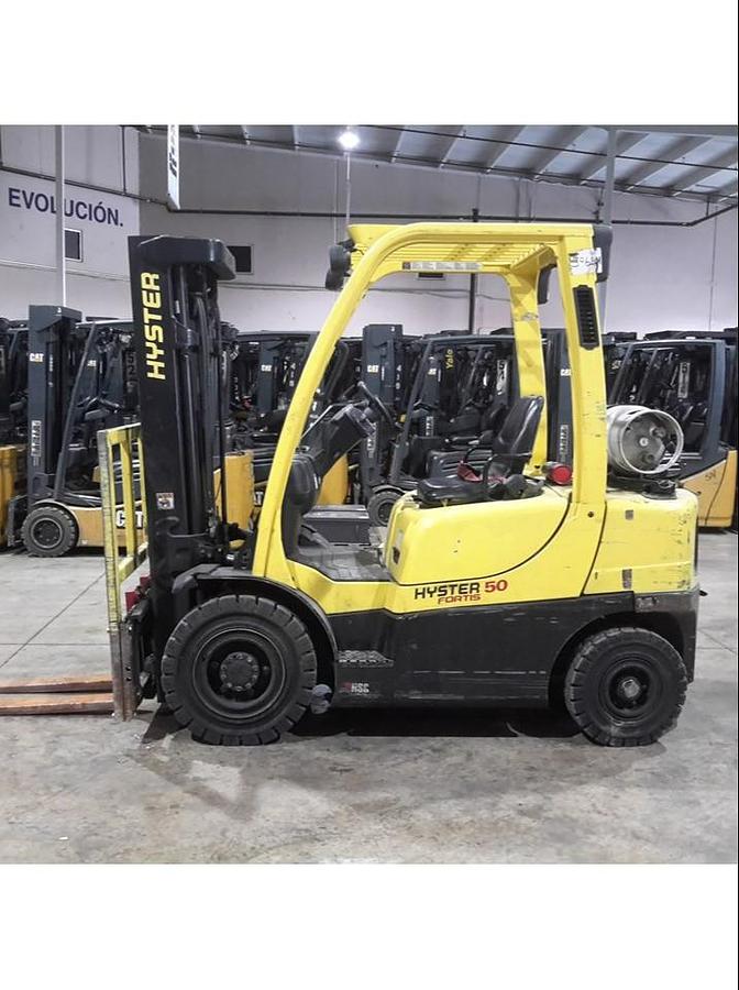 Opposite side view of refurbished 2014 Hyster H50FT LP Gas forklift showing operator compartment, pneumatic tires, 4‑wheel sit‑down chassis, and CSA certification decal during Brampton deployment.