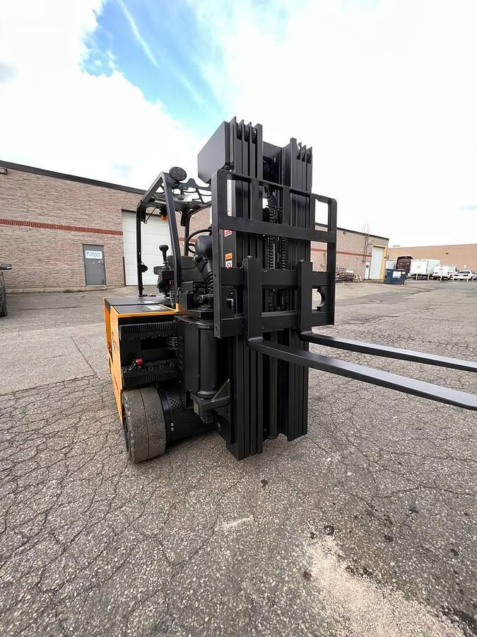 Head-on view of refurbished 2017 Drexel SL-40AC electric SwingMast forklift showing 89" collapsed quad mast, forks, base legs, and operator cab with CSA safety decals during Brampton deployment