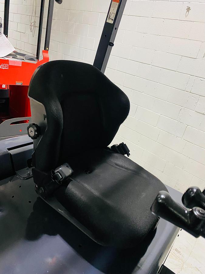 Operator seat of Toyota 8FBCU20 COM electric sit-down forklift showing padded seat, hip restraints, and CSA-certified cab – unit staged in Brampton ON