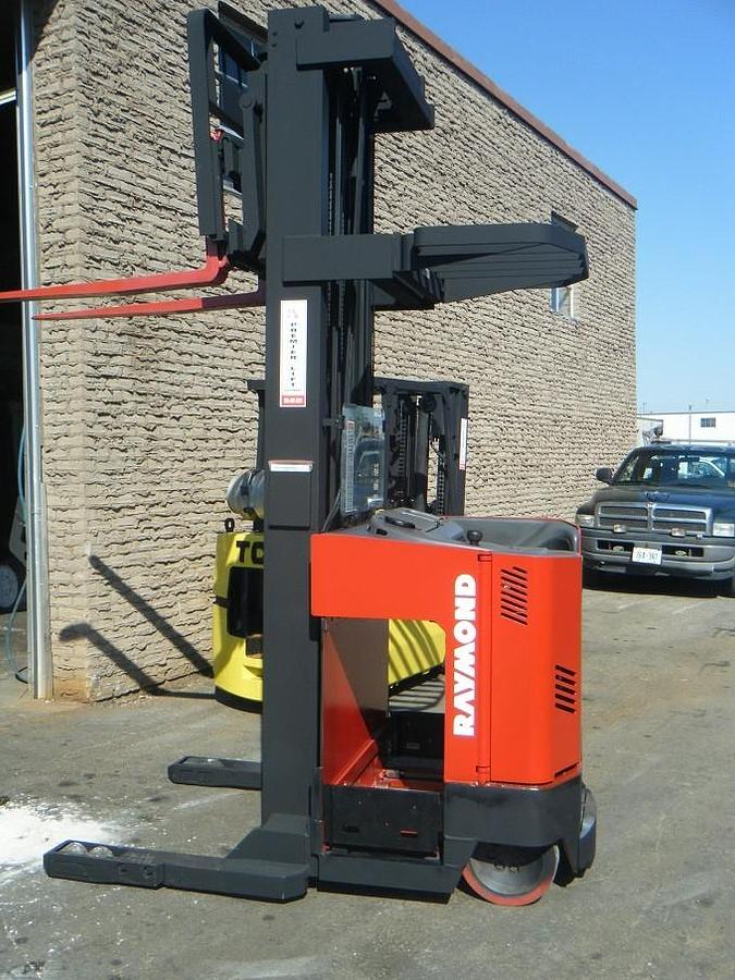 Side view of refurbished 2010 Raymond EASIR40TT electric reach truck showing narrow chassis frame, 33" base legs, and battery compartment during Oakville deployment
