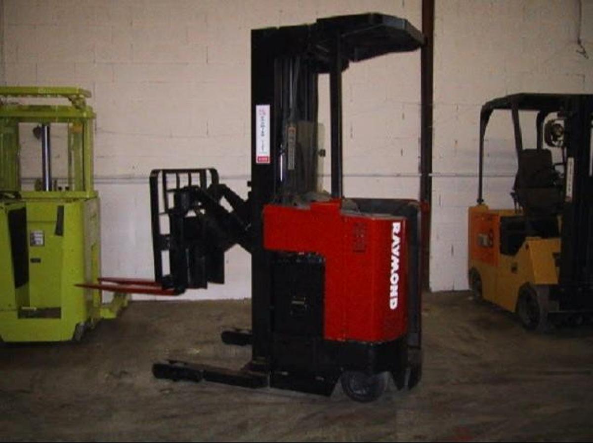 Side view of refurbished 2002 Raymond EASIR40TT electric reach truck showing reach carriage fully extended, mast rails, and chassis frame during Brampton deployment