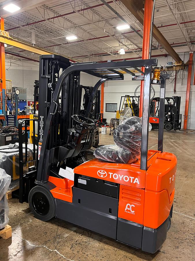 Profile view of 2014 Toyota 7FBEU18 electric forklift showing 3-wheel chassis, battery compartment, and side shift carriage
