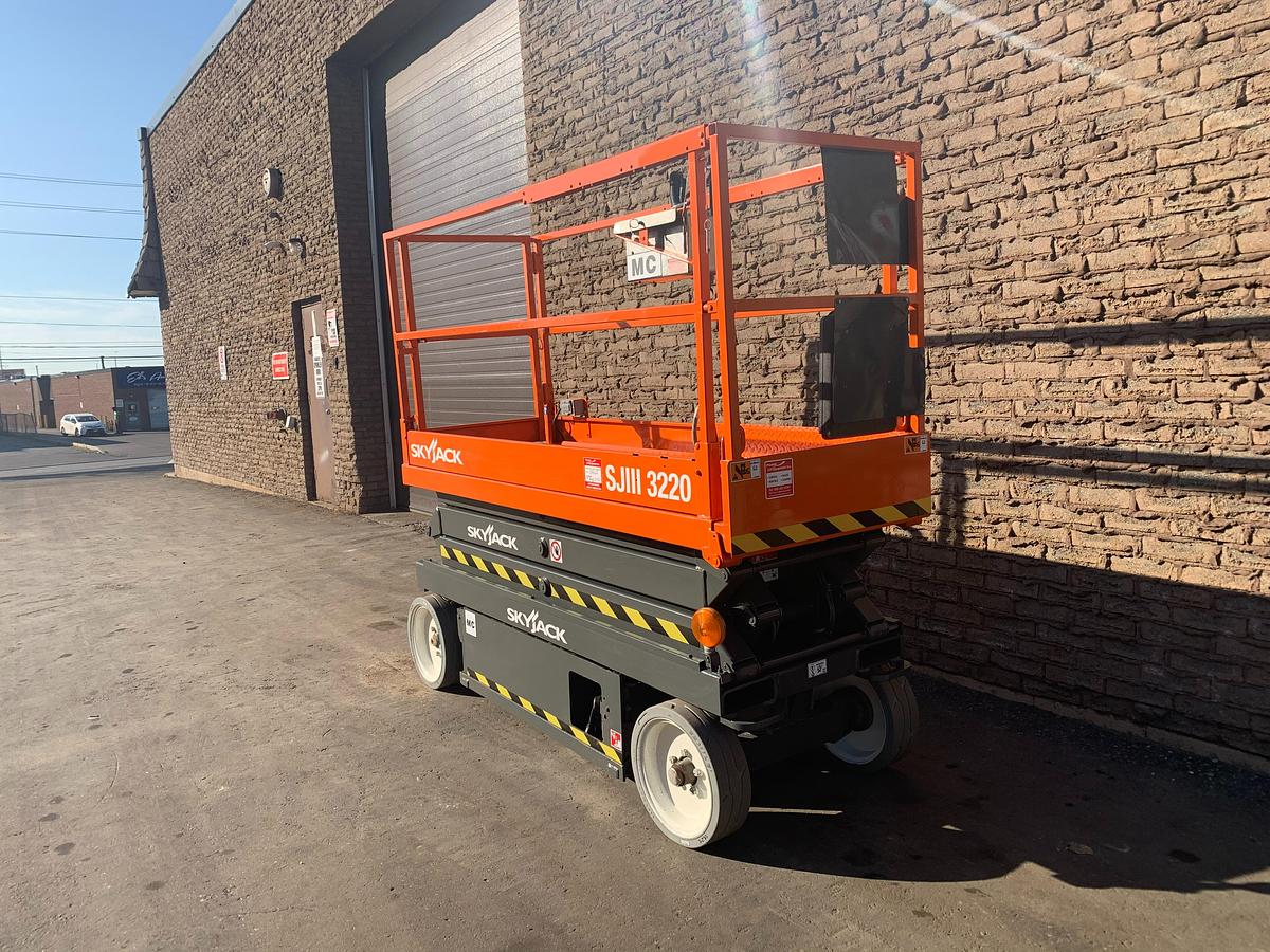 Skyjack SJIII 3220 – side angle view – slab chassis, scissor stack, CSA safety decals – electric scissor lift – Brampton ON