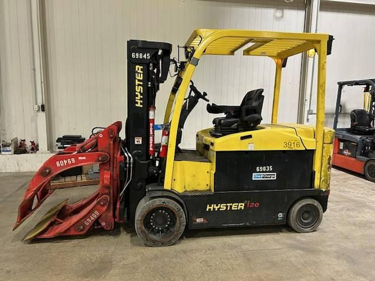 Side view of refurbished 2019 Hyster E120XN electric forklift showing paper roll clamp with 10"–60" opening, 86"/169" mast, non‑marking tires, and CSA certification decal during Ontario deployment.