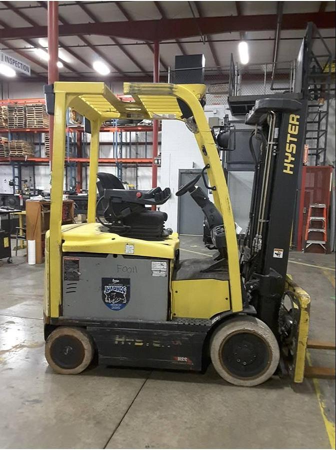 Side view of refurbished 2013 Hyster E50XN electric forklift showing 2‑stage full free lift mast, 134" lift height, side shift, solid tires, and CSA certification decal during Ontario deployment.