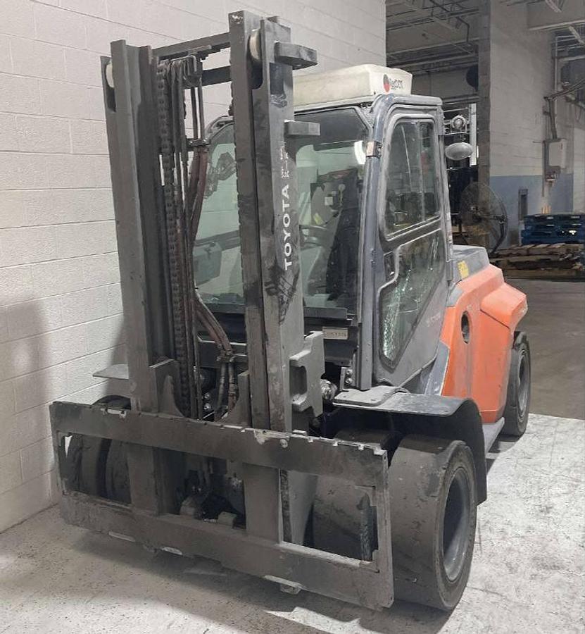 Front side view of refurbished 2019 Toyota 8FD70U diesel forklift showing mast, forks, full cab, and pneumatic tires during Brampton deployment